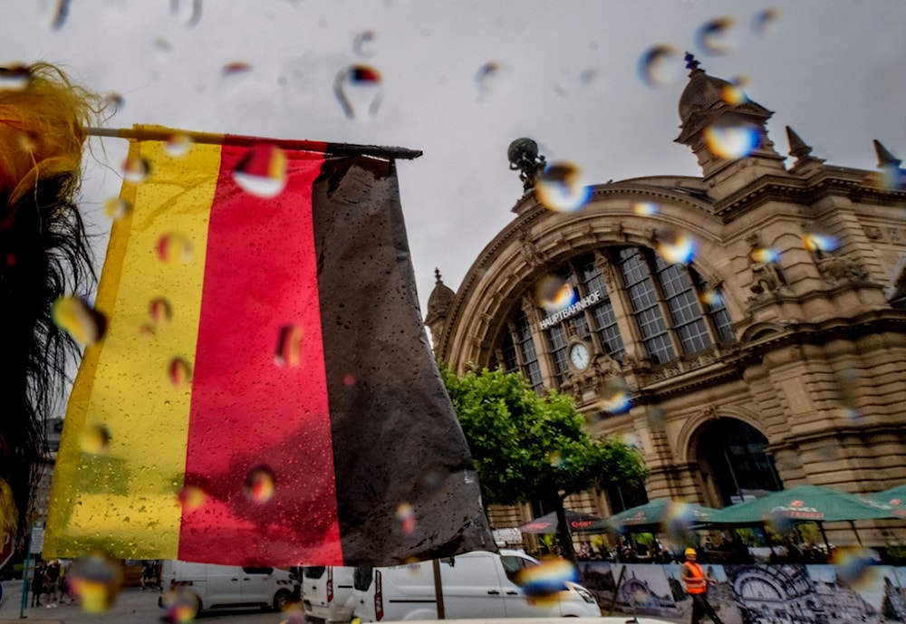 A small German national flag waves in front of the central train station in Frankfurt, Germany, on a rainy Wednesday, June 19, 2024. (AP Photo/Michael Probst)
