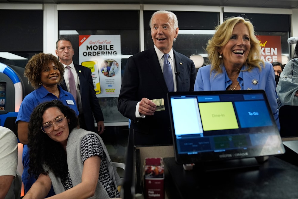 President Joe Biden, center, and first lady Jill Biden, right, pay for a purchase as they greet supporters at a Waffle House in Marietta, Ga., Friday, June 28, 2024 (AP)