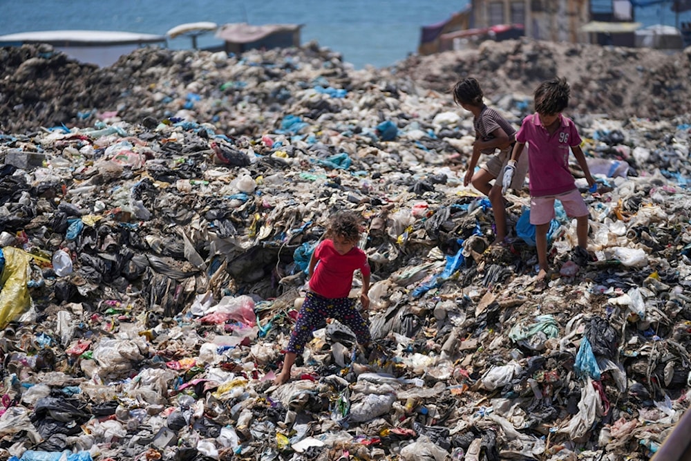 Palestinian kids sort through trash at a landfill in Nuseirat refugee camp, Gaza Strip, Thursday, June 20, 2024 (AP)