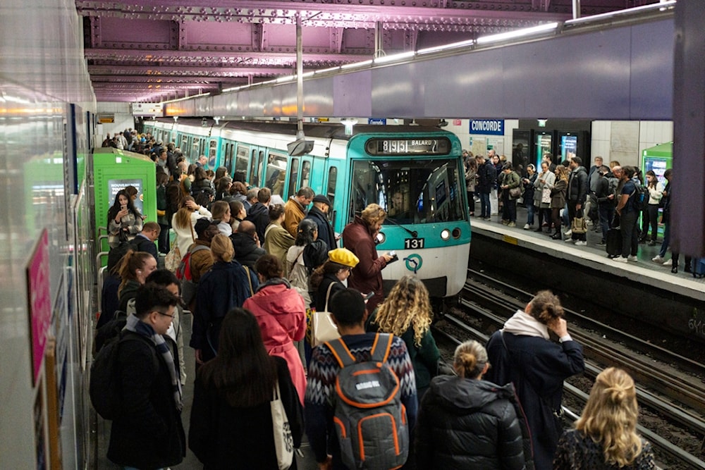 People wait for a train at the Concorde metro station in Paris, France, Tuesday, Oct. 17, 2023. (AP Photo/Pavel Golovkin)