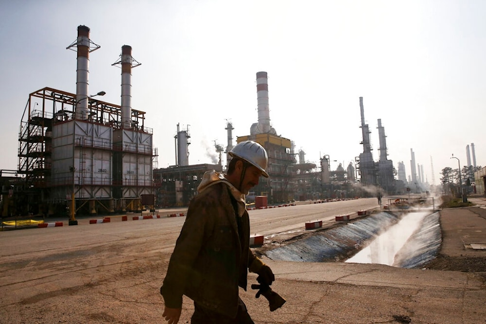 In this Dec. 22, 2014 file photo, an Iranian oil worker makes his way through Tehran's oil refinery south of the capital Tehran, Iran. (AP)