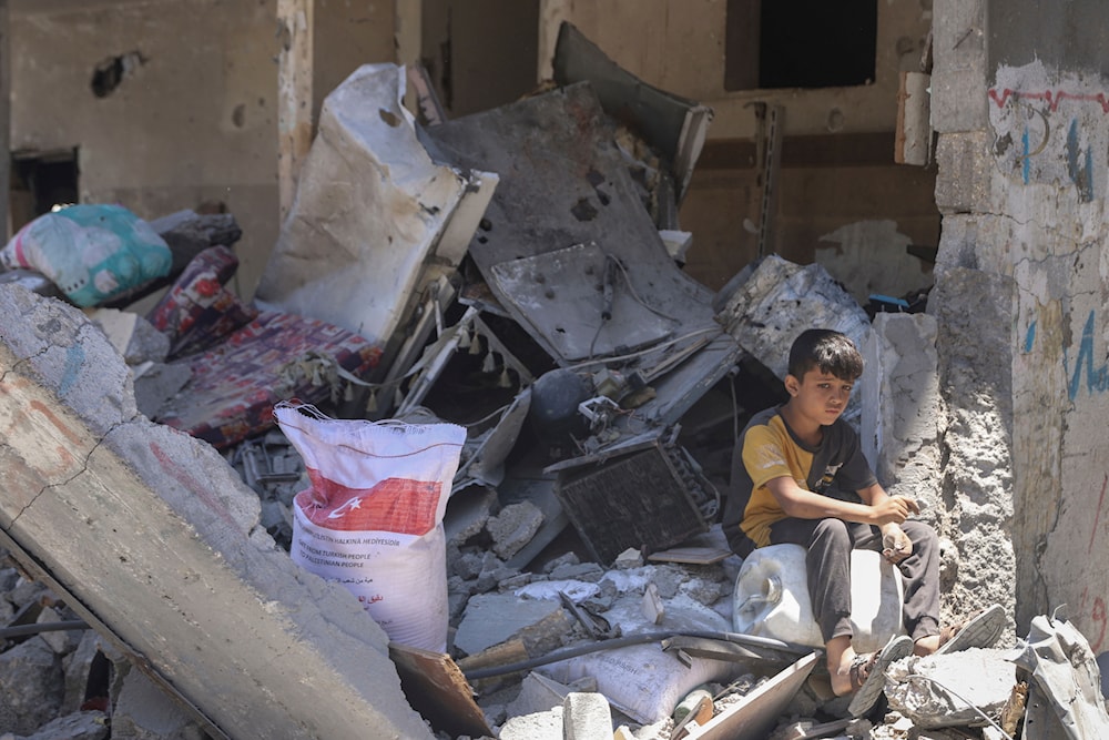 A Palestinian boy sits in the rubble of his destroyed home in Jabaliya, northern Gaza Strip after Israeli forces withdrew from the area, Friday, May 31, 2024. (AP)