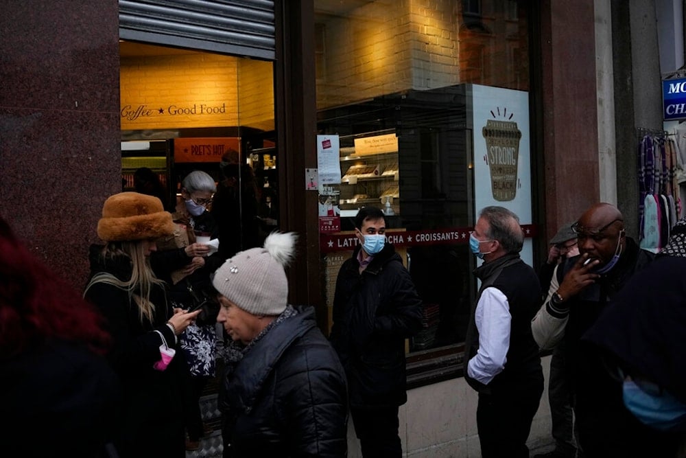 People wearing face masks to curb the spread of coronavirus queue outside a branch of the Pret a Manger sandwich chain in central London, Tuesday, Jan. 11, 2022. (AP)