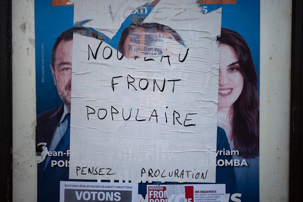 An electoral campaign board is set up in the countryside for the upcoming parliamentary elections, in Lachassagne, central France, June 25, 2024. (AP)