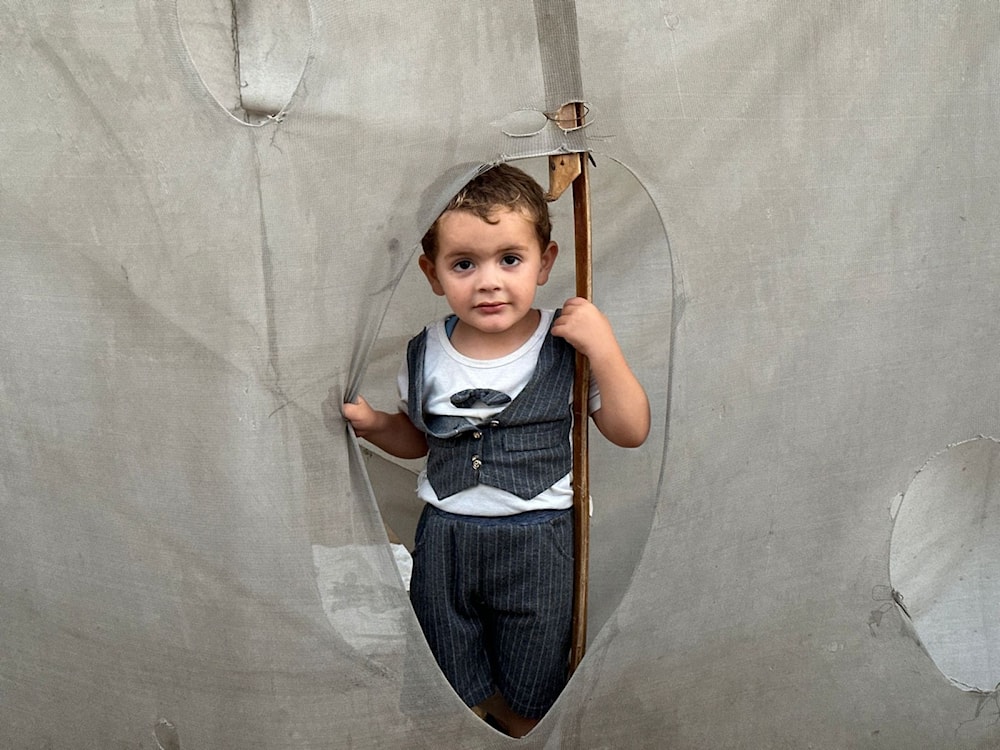 A Palestinian child sheltering on extremely overcrowded land in Deir al-Balah amid Israeli genocide on June 3, 2024. (UNRWA)