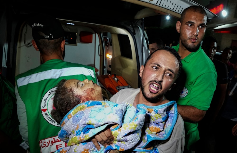 A Palestinian relative moves a child of Rewan Ghanem killed in an Israeli bombardment on a residential building owned by the Ghanem family in al-Bureij refugee camp, at al-Aqsa Martyrs hospital in Deir al-Balah, central Gaza, June 4, 2024. (AP)