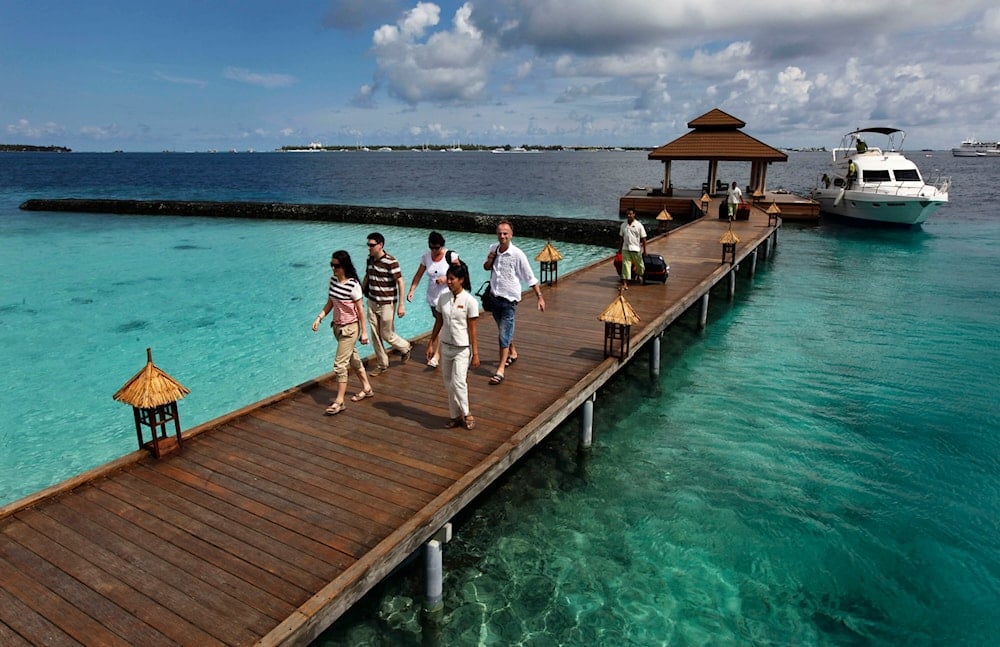 Foreign tourists arrive in a resort in the Kurumba island in Maldives, Feb. 12, 2012. (AP)