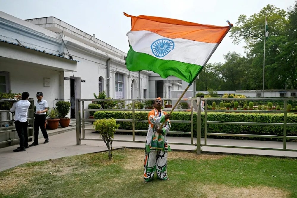 A supporter of Indian National Congress (INC) party waves India's national flag after counting of votes began for India's general election, at the INC headquarters in New Delhi [AFP]