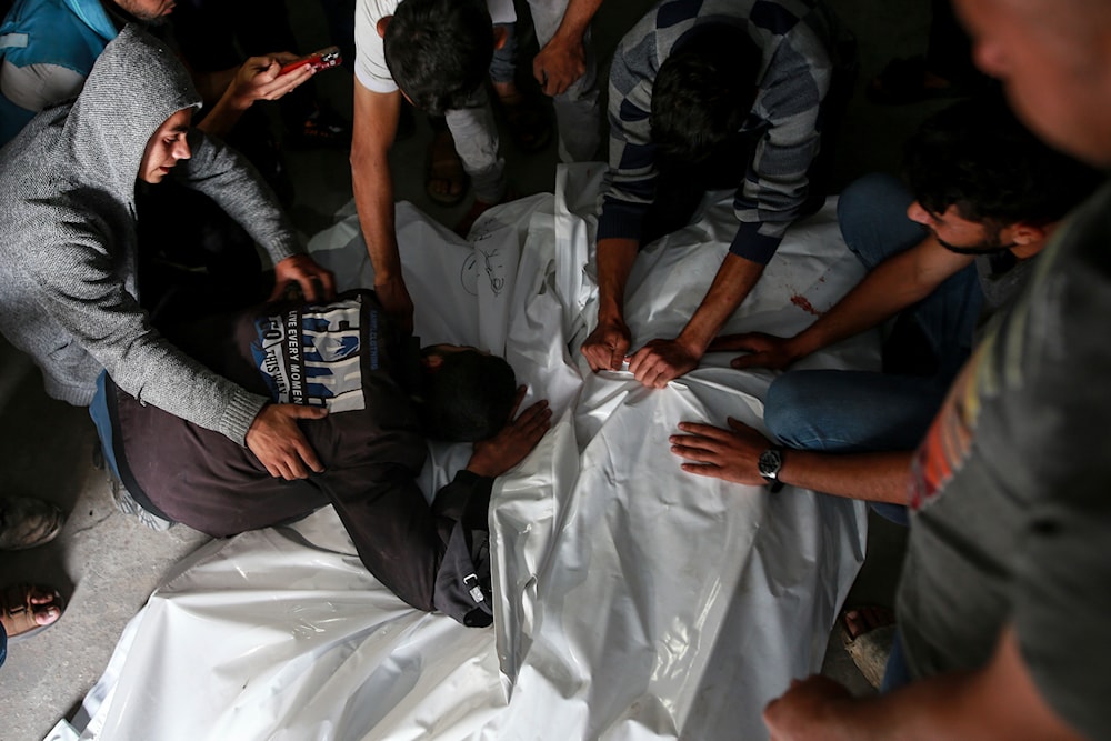 Palestinians mourn over the bodies of relatives killed in an Israeli airstrike, at a morgue in Rafah, Gaza Strip, on May 27, 2024. (AP)