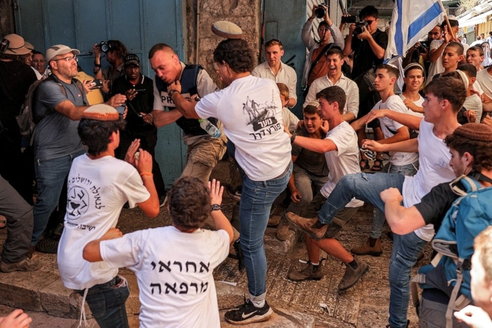 Israeli settlers assault Palestinian freelance journalist Saif Kwasmi on June 5, 2024, during the so-called Jerusalem Day Flag March. (AFP)