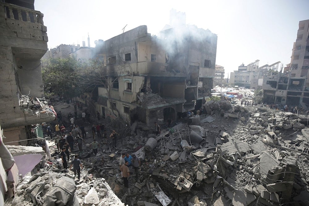 Palestinians look at the aftermath of the Israeli bombing in Nuseirat refugee camp, Gaza Strip, Saturday, June 8, 2024. (AP Photo/Jehad Alshrafi)