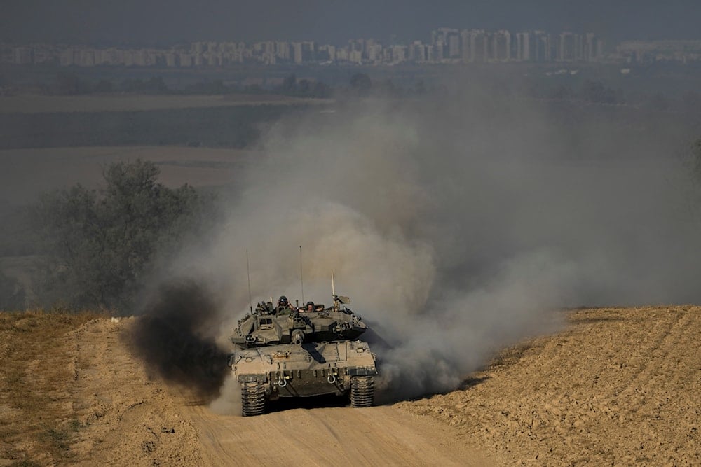 Israeli soldiers drive a tank near the Gaza Strip, in southern occupied Palestine, June 5, 2024 (AP)