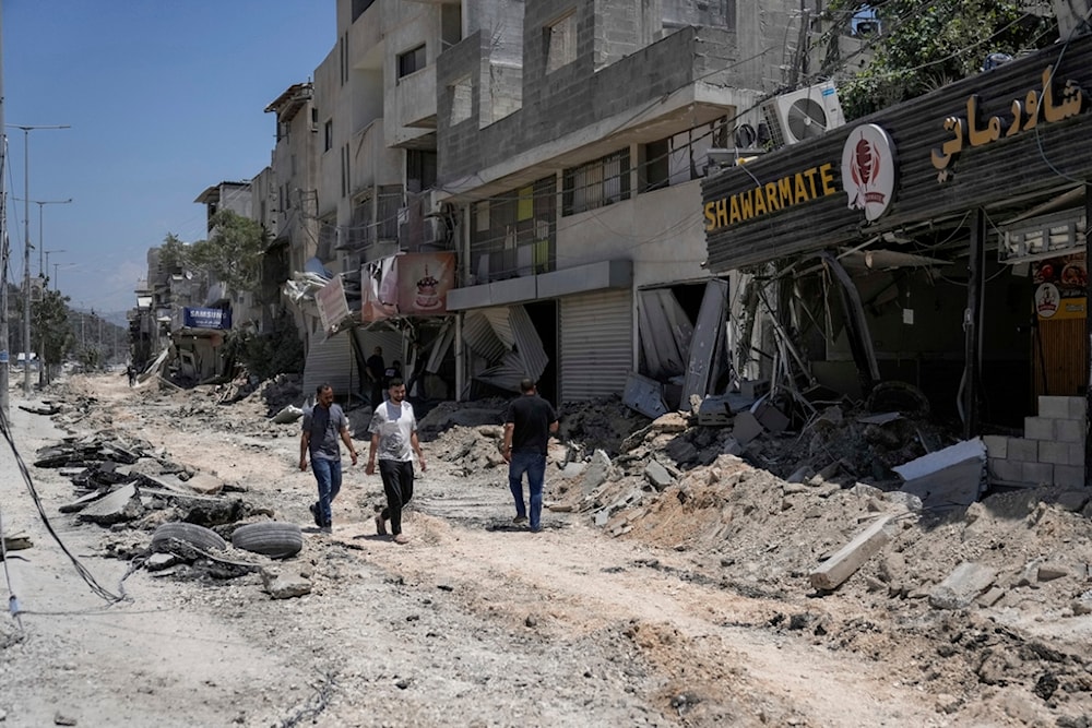Palestinians walk along a damaged road following an Israeli attack in Nur Shams refugee camp, near the West Bank town of Tulkarem, Monday, July 1, 2024 (AP Photo/Majdi Mohammed)