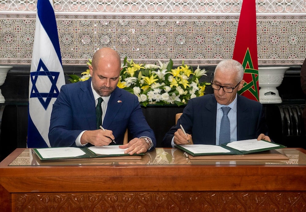 Rachid Talbi Alami, Speaker of the Moroccan House of Representatives, right, signs a bilateral deal with his Israeli counterpart, Amir Ohana, during the latter's visit to Rabat, Morocco, June, 8, 2023 (AP)