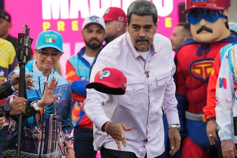 Venezuelan President Nicolas Maduro throws a cap to supporters during a campaign rally in the Boulevard of Coche in Caracas, Venezuela, Monday, July 8, 2024. (AP)