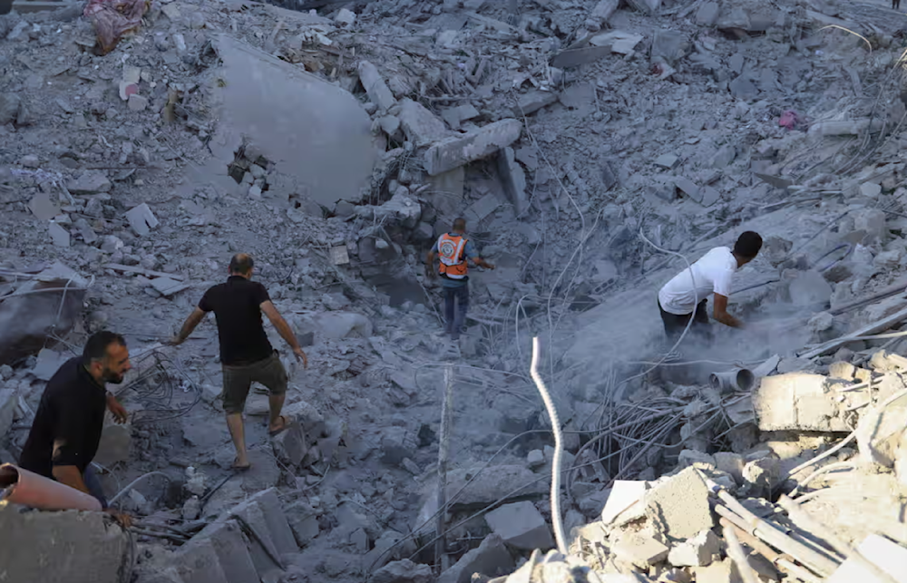 Palestinians search earlier this month for bodies and survivors in the rubble of a building destroyed in an Israeli airstrike in Khan Younis, Gaza.