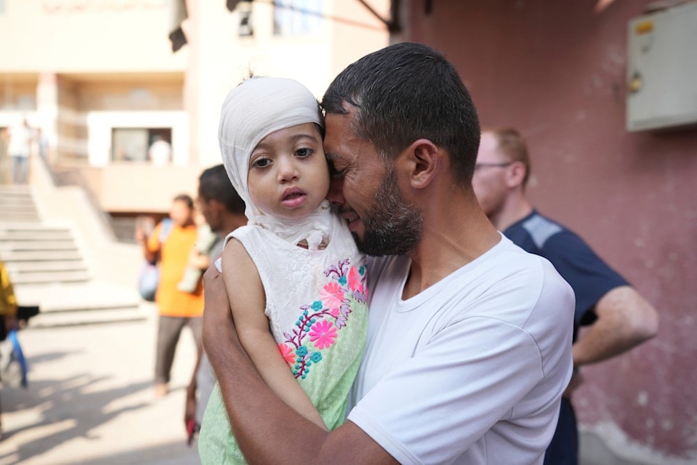 A Palestinian man reacts as he says goodbye to his sick daughter before leaving the Gaza Strip to get treatment abroad through the Kerem Shalom crossing, in Khan Younis, southern Gaza Strip, on June 27, 2024. (AP)