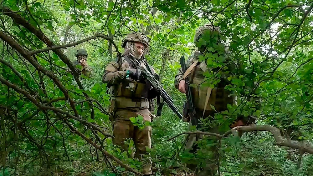 taken from video released by the Russian Defense Ministry Press Service on Wednesday, June 12, 2024, Russian soldiers walk through a forest in an undisclosed location in Ukraine. (Russian Defense/AP)