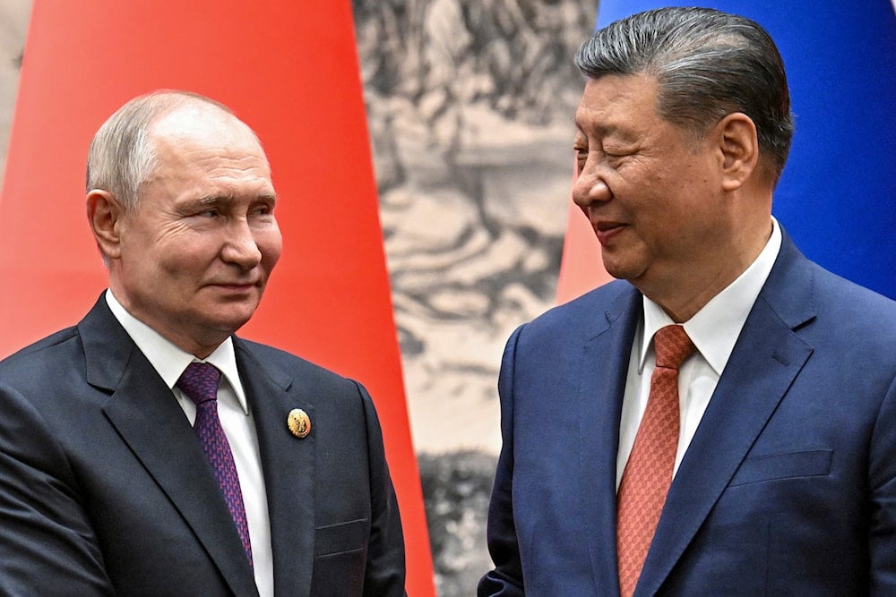 Chinese President Xi Jinping, right, and Russian President Vladimir Putin look toward each other as they shake hands prior to their talks in Beijing, China, Thursday, May 16, 2024. (AP)