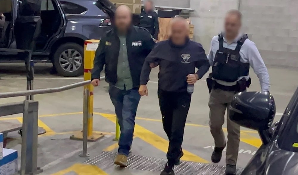 Australian Federal Police officers escort a Russian-born man arrested on suspicion of spying for Russia, July 12, 2024. (AFP)