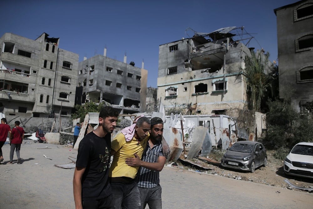 Palestinians help a wounded man after Israeli strikes in Nuseirat refugee camp, Gaza Strip, occupied Palestine, on June 8, 2024 (AP)