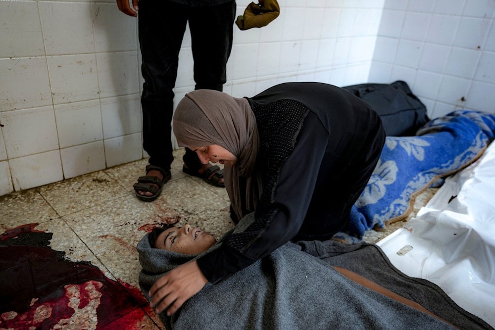 A Palestinian woman mourns over the body of a relative killed in the Israeli bombardment of the Gaza Strip, at a hospital morgue in Deir al-Balah, on July 13, 2024. (AP)