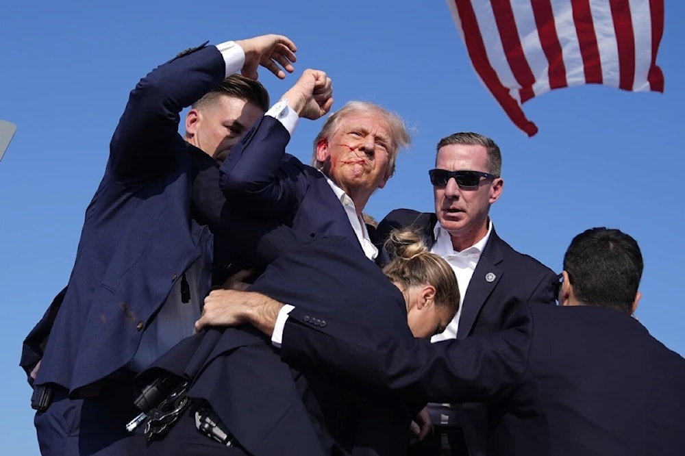 Security evacuate a bloody Donald Trump after he got shot while giving a speech in Pennsylvania, July 14, 2024 (Social Media)