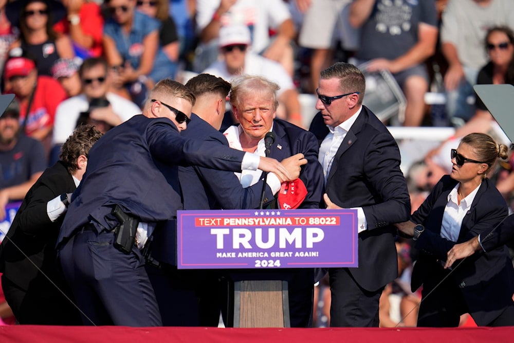 Republican presidential candidate former President Donald Trump is helped off the stage at a campaign event in Butler, Pa., on July 13, 2024. (AP)