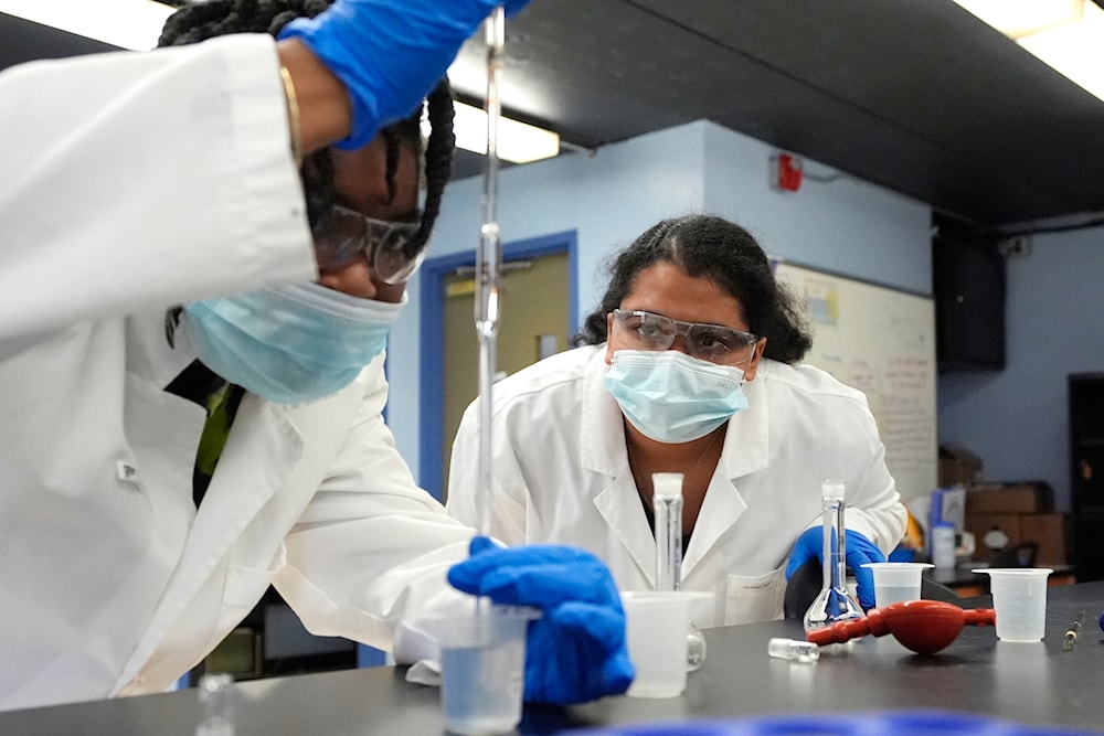 Sima Gutierrez, right, observes as a teammate examines water at the Flint Community Water Lab, Wednesday, April 3, 2024, in Flint, Mich. (AP)