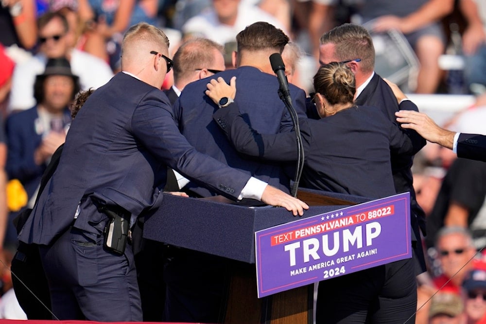 Republican presidential candidate former President Donald Trump is surrounded by U.S. Secret Service at a campaign event in Butler, Pa., on Saturday, July 13, 2024. (AP Photo/Gene J. Puskar)