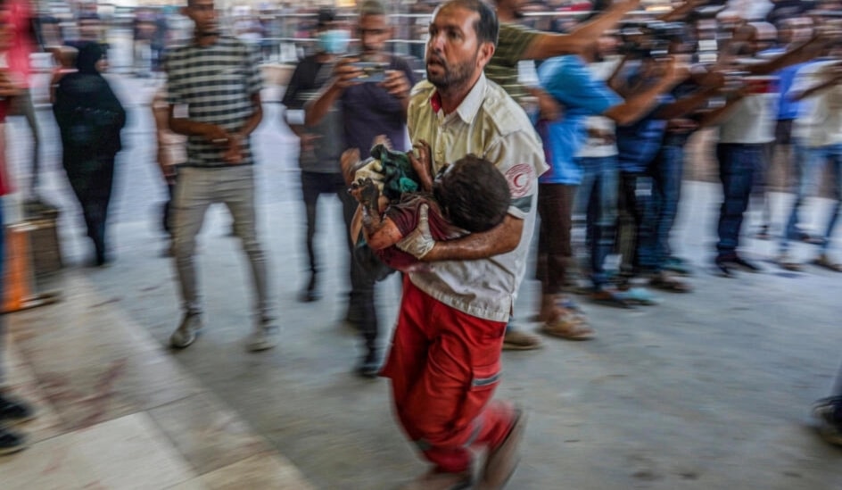 A paramedic carries a child wounded during Israeli bombardment to the emergency ward at Nassr hospital in Khan Younis, southern Gaza Strip, July 9, 2024. (AFP)