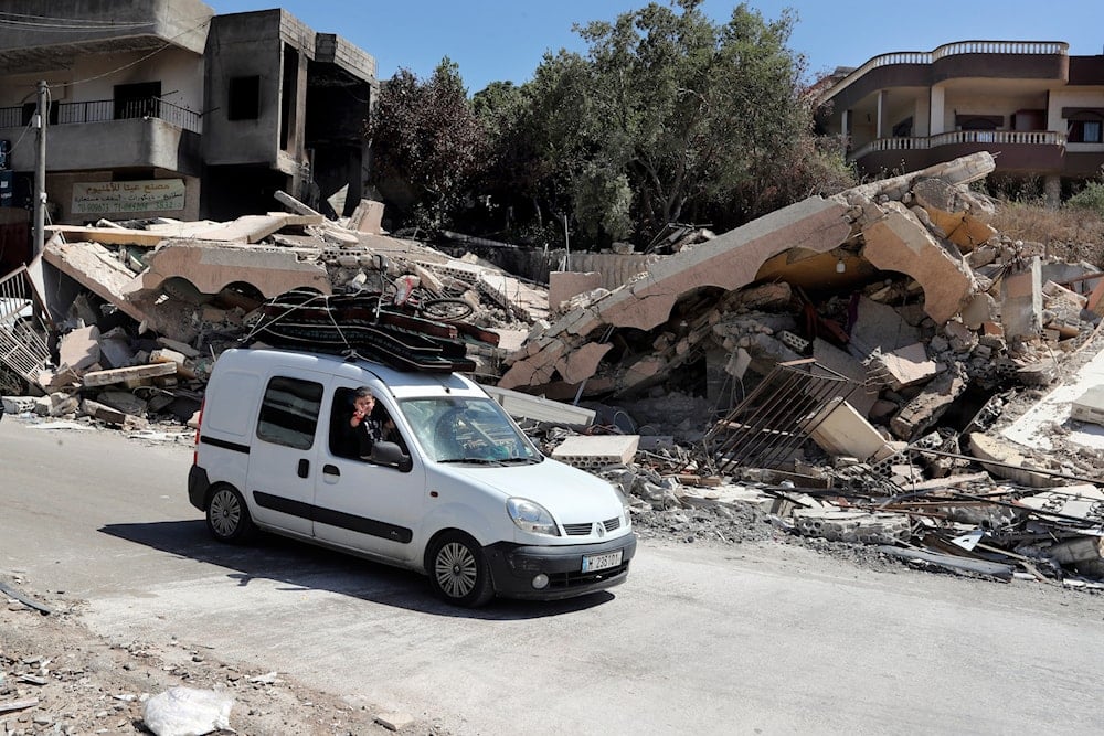 A car drives by a destroyed house that was hit by an Israeli airstrike, in Aita al-Shaab village, south Lebanon, June 29, 2024 (AP)