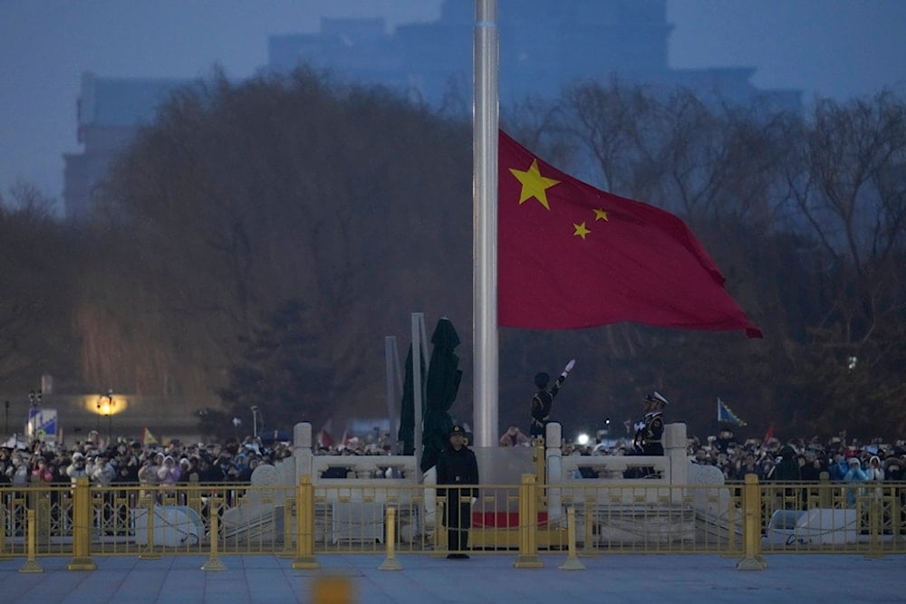 A member of the Chinese honor guard unfurls the Chinese national flag during a flag raising ceremony at the Tiananmen Square in Beijing, China, Tuesday, March 5, 2024. (AP Photo)