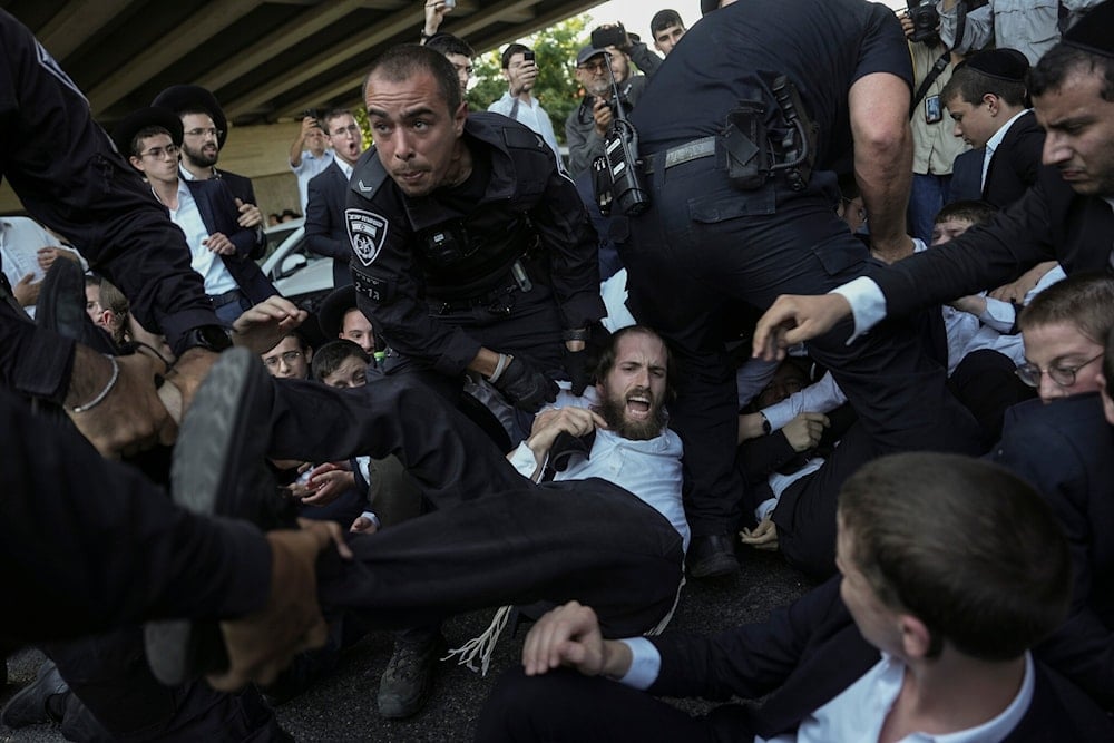 Israeli police disperse ultra-Orthodox Jews blocking a highway during a protest against army recruitment in Bnei Brak, occupied Palestine, Thursday, June 27, 2024. (AP)