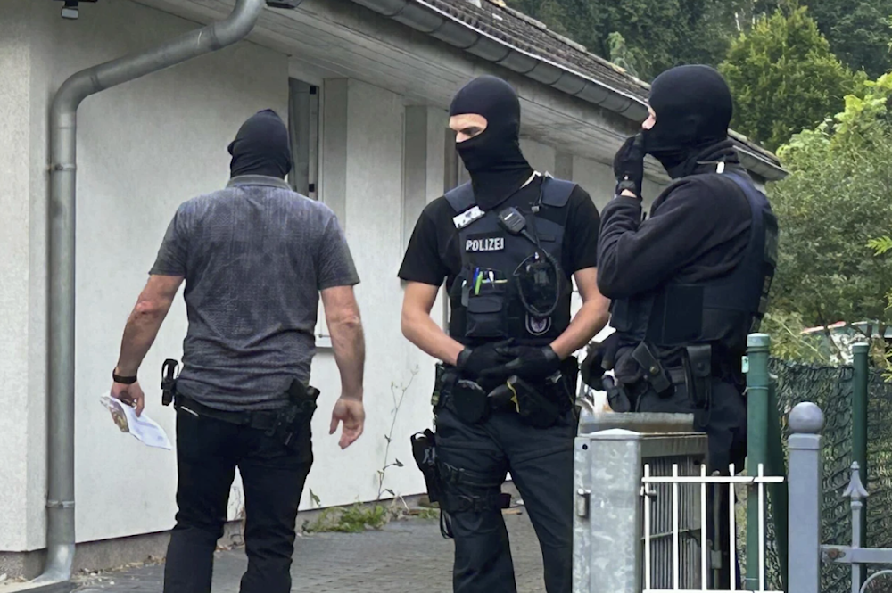 Masked police officers stand in front of a house in falkensee near Berlin, Germany on July 16, 2024. (AP)