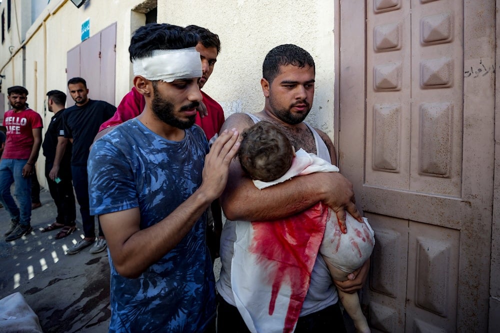 Palestinian Mahmoud Mikdad holds the body of his 21-month-old child Yaman, killed in the Israeli bombardment of the Gaza Strip, at a hospital morgue in Deir al-Balah, Tuesday, on July 16, 2024. (AP)