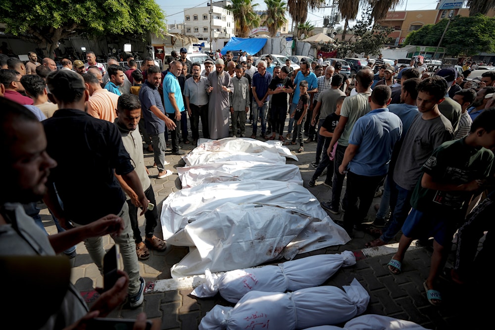 Palestinians gather near the bodies of their relatives killed in the Israeli bombardment of the Gaza Strip, at a hospital morgue in Deir al-Balah, Tuesday, July 16, 2024. (AP)