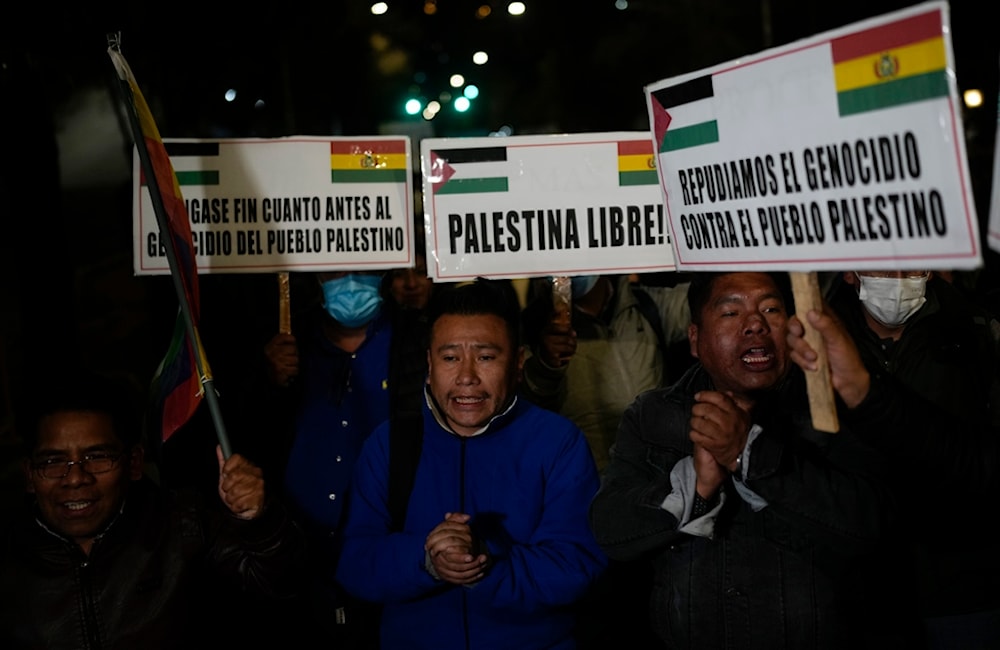 Pro-Palestinian demonstrators hold banners in Spanish lambasting 