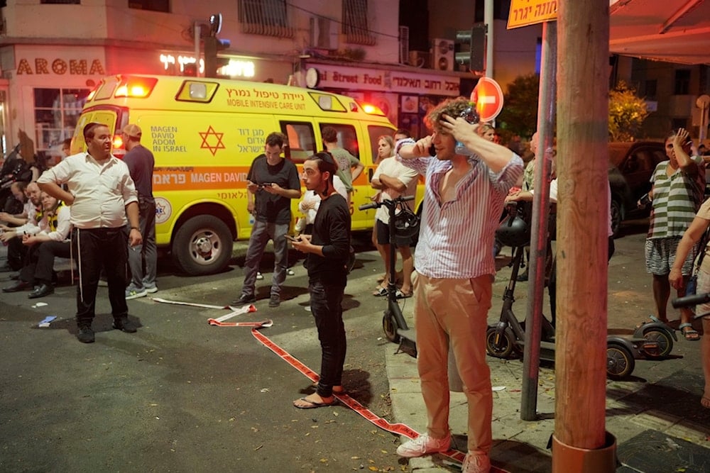 People gather at the scene of Yemen's drone strike in Tel Aviv, occupied Palestine, early Friday, July 19, 2024. (AP)