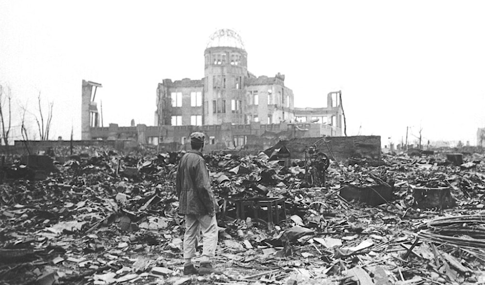 In this 1945 file photo, an Allied war correspondent stands in the ruins of Hiroshima, Japan, just weeks after the city was leveled by an atomic bomb. (AP)