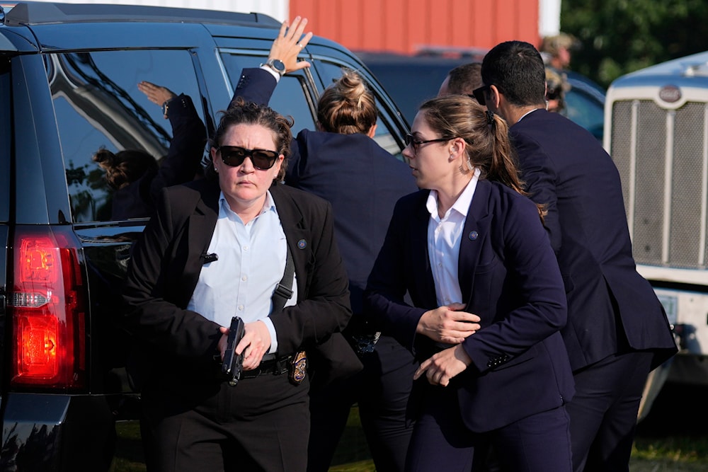 U.S. Secret Service agents surround the vehicle carrying Republican presidential candidate former President Donald Trump at a campaign rally, Saturday, July 13, 2024, in Butler, Pa. (AP)