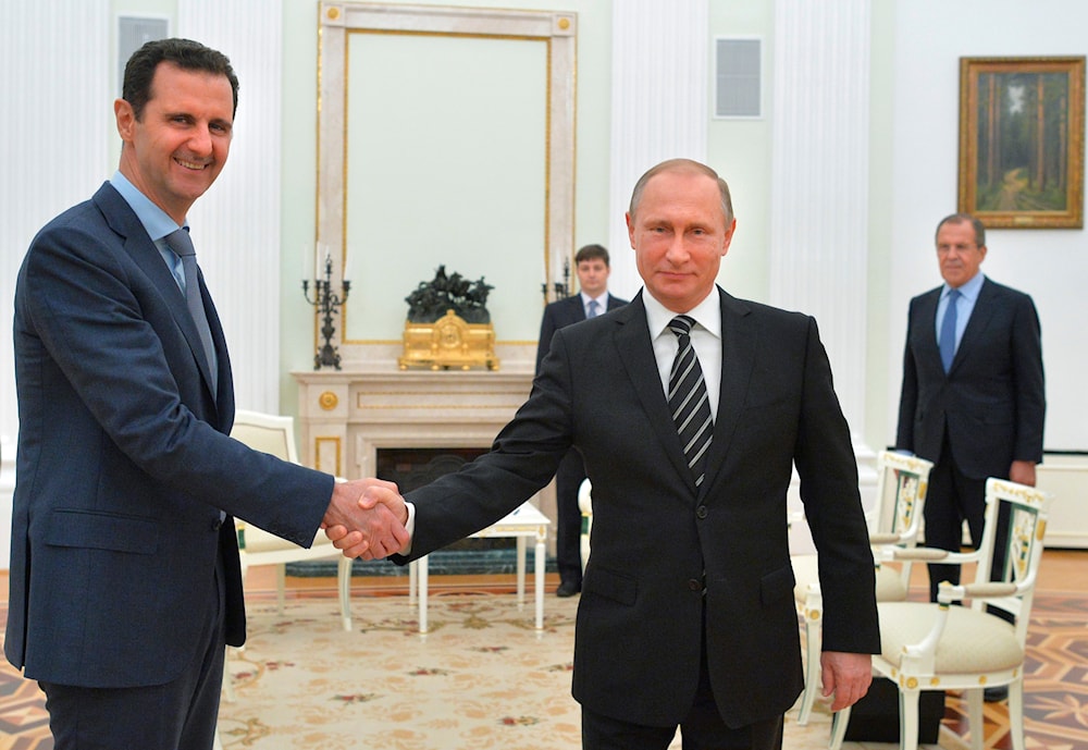 Russian President Vladimir Putin shakes hands with Syrian President Bashar Assad as Russian Foreign Minister Sergey Lavrov looks on, in Moscow, Oct. 20, 2015. (AP)