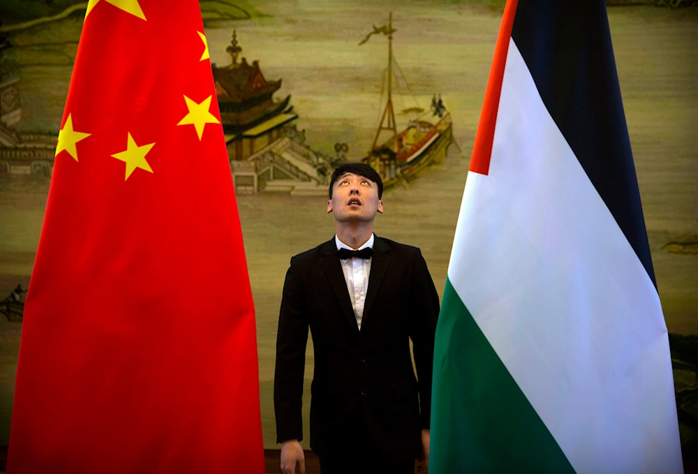 A staff member checks the alignment of Chinese, left, and Palestinian flags before the start of a joint press conference at the Ministry of Foreign Affairs in Beijing, China, April 13, 2017 (AP)