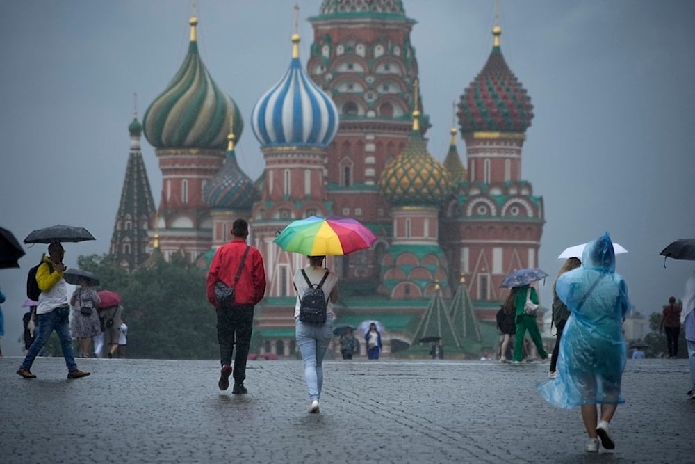 People with umbrellas walk through Red Square under rain in Moscow, Russia, Monday, July 22, 2024. After hot weather, the temperature in Moscow dropped to 22 Celsius, (71,6 Fahrenheit) . (AP)