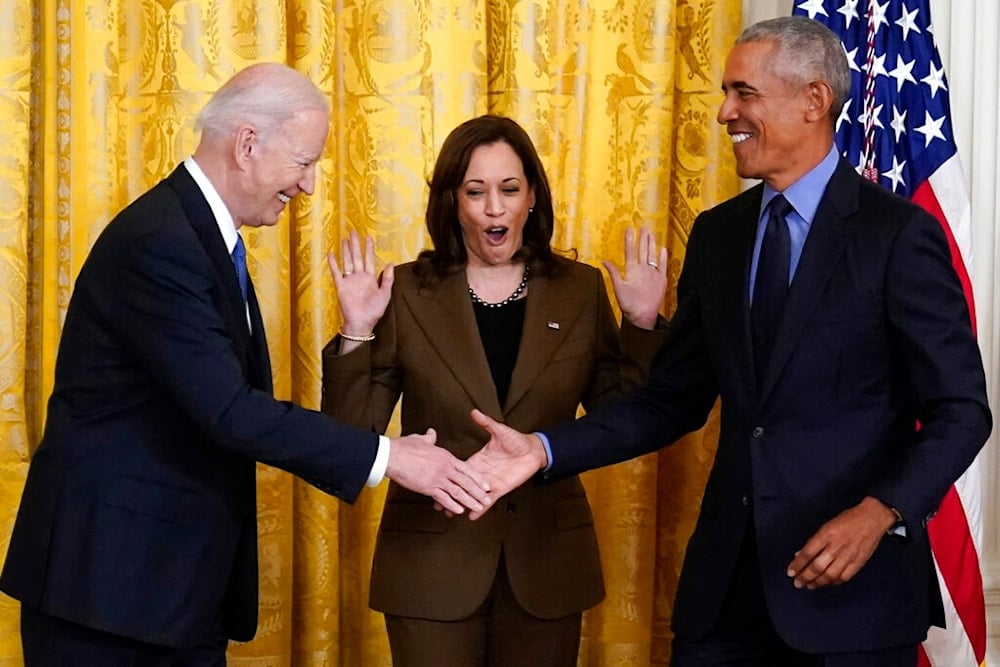 Vice President Kamala Harris reacts as President Joe Biden and former President Barack Obama shake hands on stage, in the East Room of the White House in Washington, Tuesday, April 5, 2022. (AP)