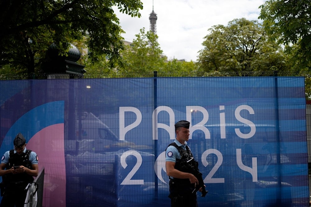 Police officers patrol near the Eiffel Tower, partially seen in background, at the 2024 Summer Olympics, Monday, July 22, 2024, in Paris, France. (AP Photo/Natacha Pisarenko)