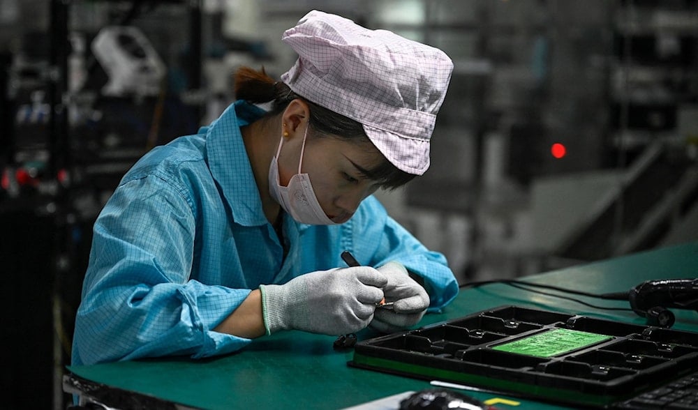 An employee works on a smartphone production line at an OPPO factory in Dongguan, Guangdong province, July 20, 2022. (AFP)