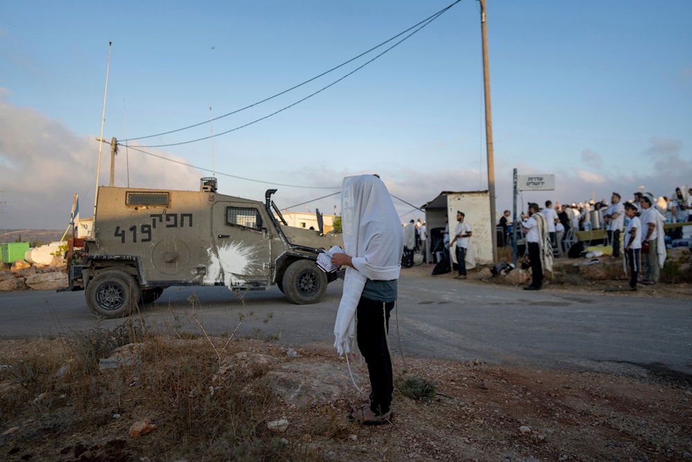 Israeli settlers pray in the Eviatar outpost in the Israeli-occupied West Bank during morning prayers calling for the legalization of the outpost, July 7, 2024 (AP)