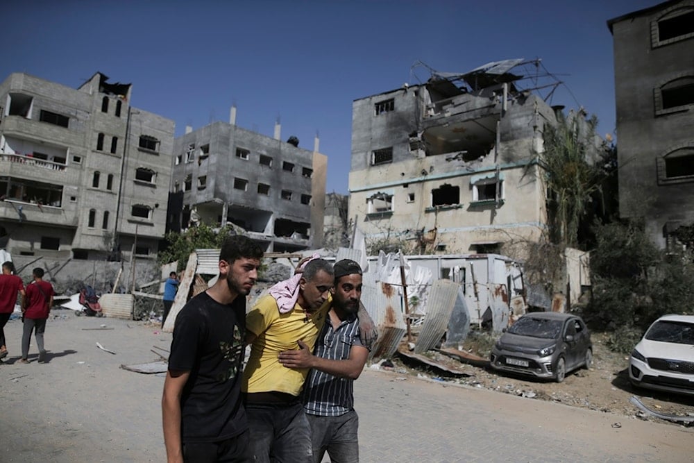 Palestinians help a wounded man after Israeli strikes in Nuseirat refugee camp, Gaza Strip, June 8, 2024 (AP) 