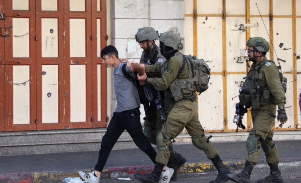 Israeli occupation forces detain a Palestinian youth in the Bab al-Zawiya area in the Palestinian city of al-Khalil in the occupied West Bank on September 29, 2022. (AFP)